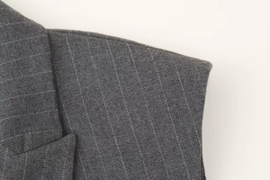Détail du tissu à rayures gris foncé montrant l'épaule et le col d'un gilet sans manches