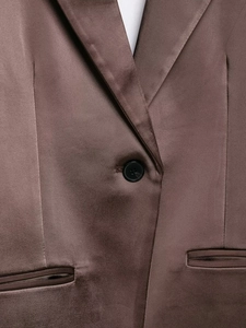Detailed macro view of deep brown satin blazer texture with peak lapels and buttons