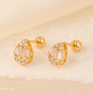 Macro view of gold teardrop earrings with baguette and round cubic zirconia studs