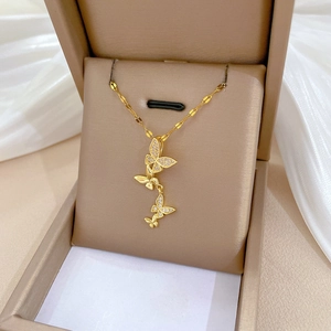 Detail of gold butterfly necklace with crystal inlay in a luxury jewelry display box