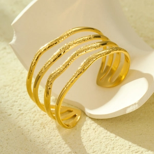 Elegant gold-tone multi-layer open cuff bracelet with hammer-textured wave pattern