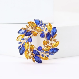 Elegant wheat wreath brooch with deep blue and yellow crystals on a gold alloy base