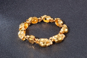 Macro view showing the detailed 3D golden skull links and gothic punk clasp mechanism