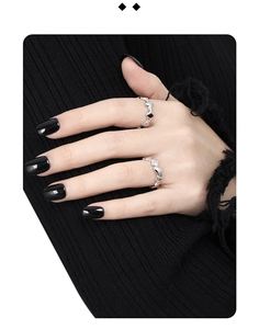 Detail view of two geometric S925 silver rings on model with black knitwear background