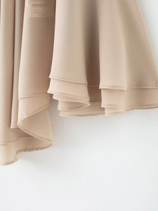 Detail of layered beige chiffon hem showing delicate texture and fluid drape