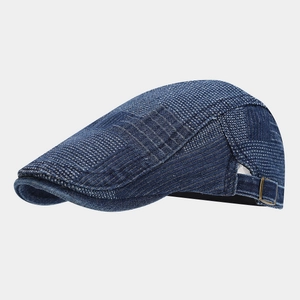 Detail view of denim flat cap featuring textured fabric and adjustable vintage copper buckle
