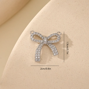Detailed size view of silver bow pendant with zircons showing 2x1.9cm measurements