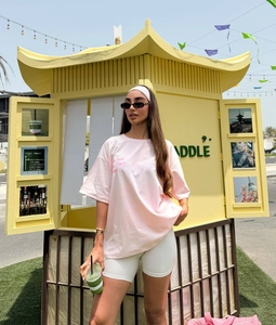 Pink oversized t-shirt with Girls Just Wanna Have Fun slogan and white cycling shorts