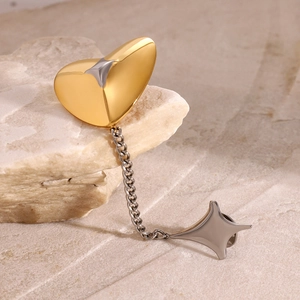 Elegant two-tone heart and star brooch with delicate metal chain on natural stone