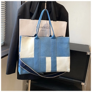Detail view of large canvas tote bag with blue and beige color blocking and straps
