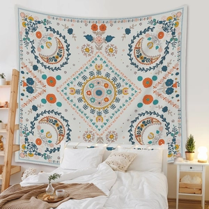 Detail of bohemian tapestry featuring floral and moon motifs on a bedroom wall decoration