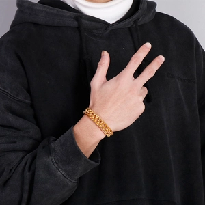 Detail of chunky gold stainless steel braided chain bracelet worn on male model wrist
