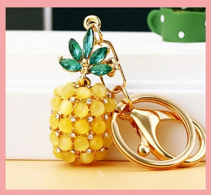 Close-up of golden pineapple keychain with yellow opal beads and green crystals