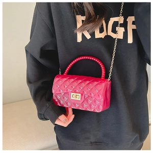 Detail of pink jelly crossbody bag featuring quilted PVC pattern and beaded handle