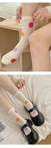 Detail of white mesh crew socks with colorful polka dots paired with Mary Jane shoes