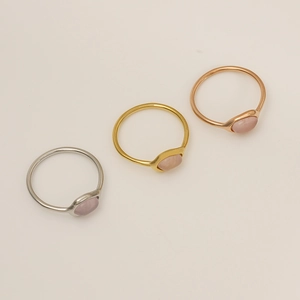 Détail de trois bagues en acier avec cristaux roses en argent or et or rose