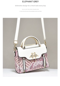 Close-up of elephant grey handbag featuring white flap and flamingo clasp detail