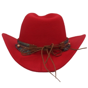 Detail of red wool felt cowboy hat with ethnic braided band and tassel fringe