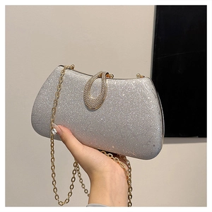 Close-up of silver sequin evening bag featuring a gold chain and diamond oval clasp