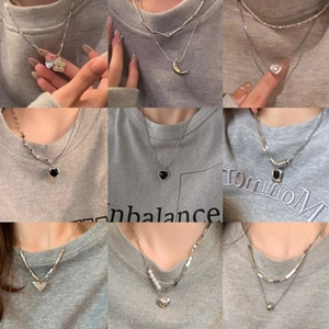 Neuf colliers argentés élégants avec pendentifs cœur et lune en grille 3x3