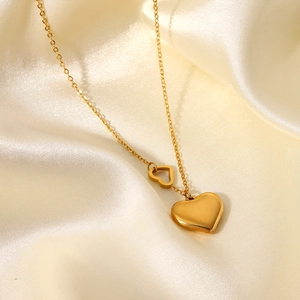 Detailed close-up of 18K gold-plated double heart necklace on elegant champagne satin