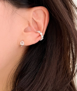 Close-up of vintage silver heart gemstone stud and shimmering zircon ear cuff on ear