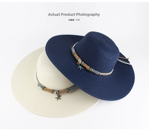 Detail view of wide brim straw hats in navy blue and cream with star charms