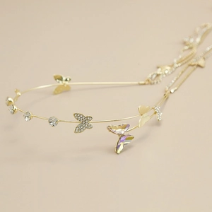 Macro detail of golden butterfly headband featuring sparkling rhinestones and crystal accents