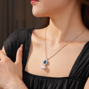 Primo piano della collana vintage con pietra blu, perle e piccoli diamanti scintillanti