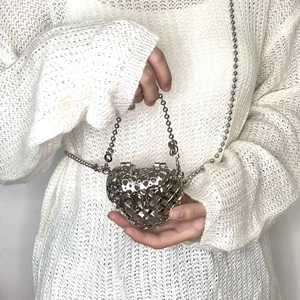Detail of silver heart-shaped hollow metal bag with decorative bead chain strap