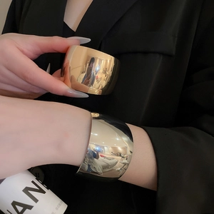 Polished metallic wide-band open knot bracelets in shiny gold and silver finishes