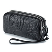 Macro view of black leather handbag featuring rose embossed pattern and three zipper layers