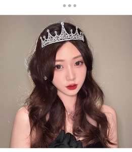 Detailed view of a silver baroque tiara with sparkling rhinestones worn by a model