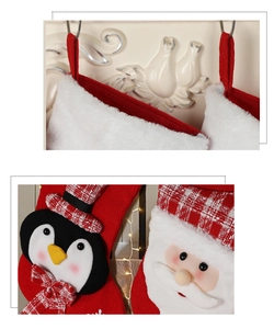 Close-up of plush penguin and Santa Claus figures on knitted Christmas stockings