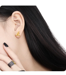 Detailed close-up of irregular gold twig earrings with diamonds on female model