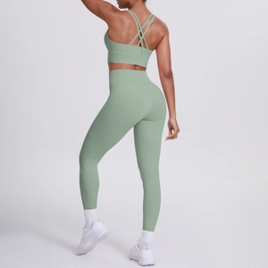 Vista posteriore del set yoga verde salvia con reggiseno sportivo incrociato e leggings a vita alta