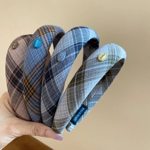 Detail of four Korean style plaid headbands with fabric texture and metal logo accents