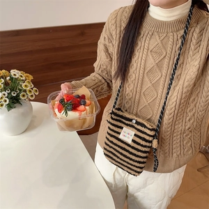 Détail du sac bandoulière en peluche rayé noir et beige avec sangle tissée et fermoir