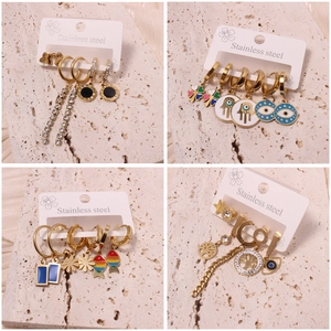 Three-pair set of gold stainless steel stud earrings featuring clover and evil eye designs