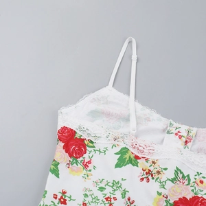 Detail of floral lace trim and adjustable spaghetti straps on white camisole top