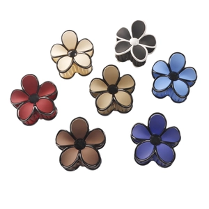 Petal-shaped matte and glossy hair claws in seven assorted colors on white background