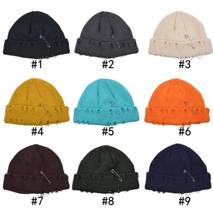Nine-color grid of distressed knit beanies with safety pins and metal rings streetwear style