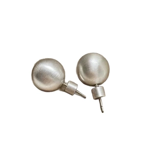 Minimalist silver stud earrings with a brushed matte texture and spherical design