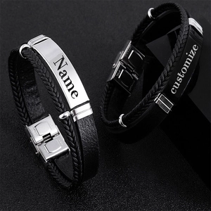 Macro shot of customized braided leather bracelets with engraved stainless steel nameplates