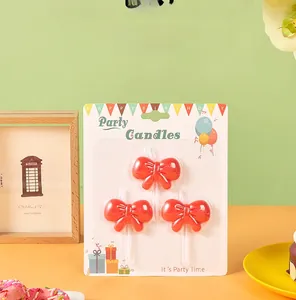 Detailed view of red bow birthday candles set on festive decorative backing card