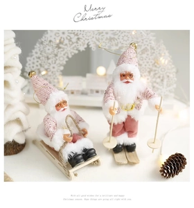 Pink and white Santa Claus plush figurines on sleds with festive wood and knit texture