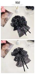 Close-up of elegant floral print tulle hair claws with long satin bow streamers in black