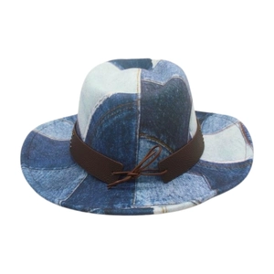 Detail view of a patchwork denim cowboy hat with brown faux leather band and bow decoration