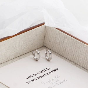 Macro shot of S925 sterling silver hoop earrings with clear gemstones in a jewelry box