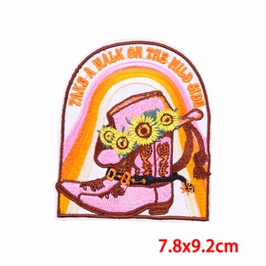 Detail of flower cowboy boot patch with sun flower and Take a walk on the wild side text